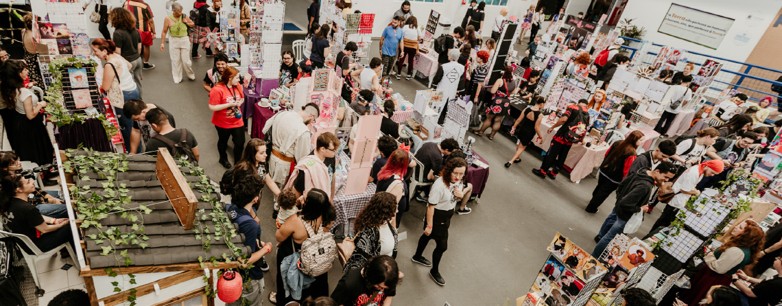 imagem da area de beco dos criadores, com as mesas dos artistas e o público visitando